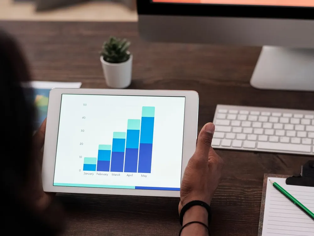 Business owner reviewing a rising bar chart on a tablet